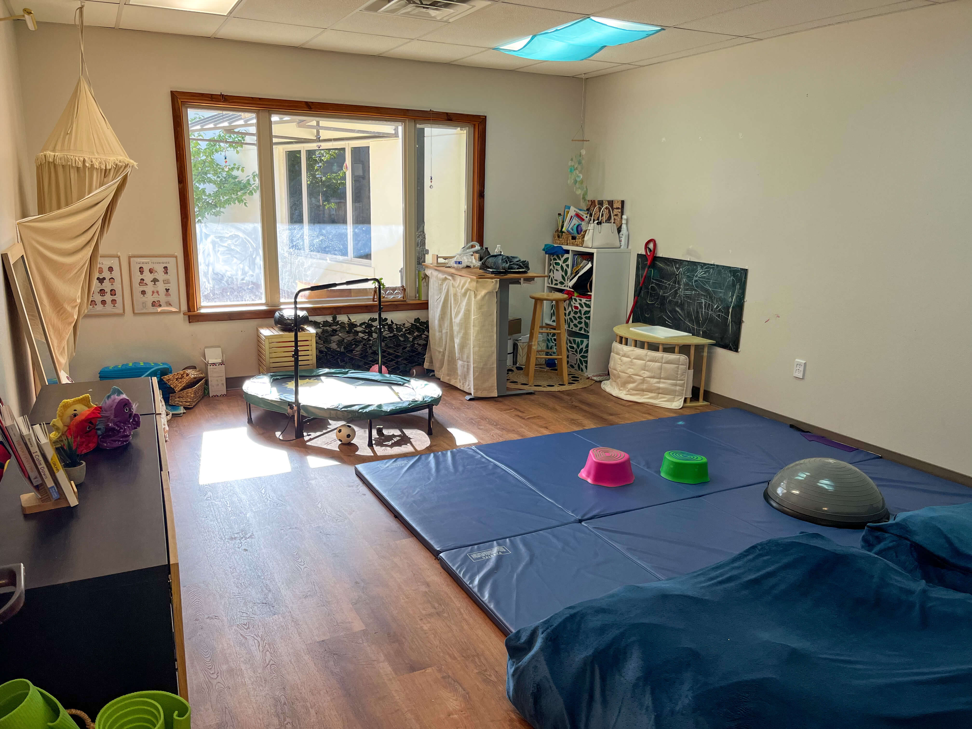 A space is shown with floormats and materials to engage gross motor skills