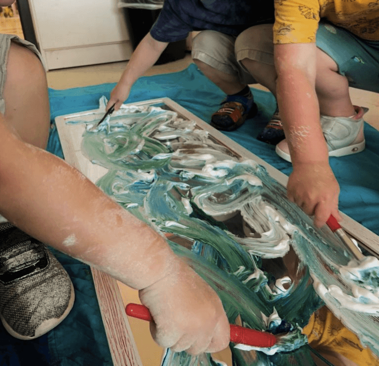 A group of children painting with shaving cream